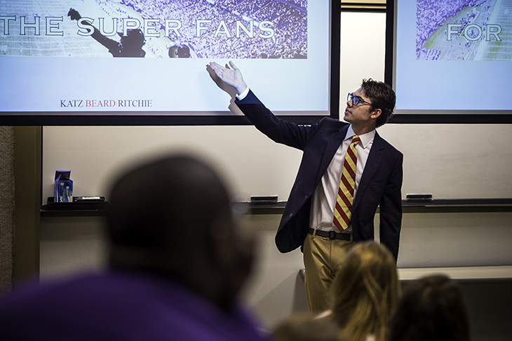Hamilton Beard explains his group's billboard during a presentation before representatives of the Greater New Orleans Sports Foundation and his fellow classmates in management communications (MCOM 3010). (Photo by Ryan Rivet)