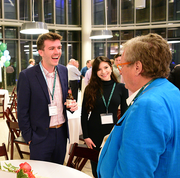 MBA Student Conner Commeaux talks with 50th reunion class member at reunion party.