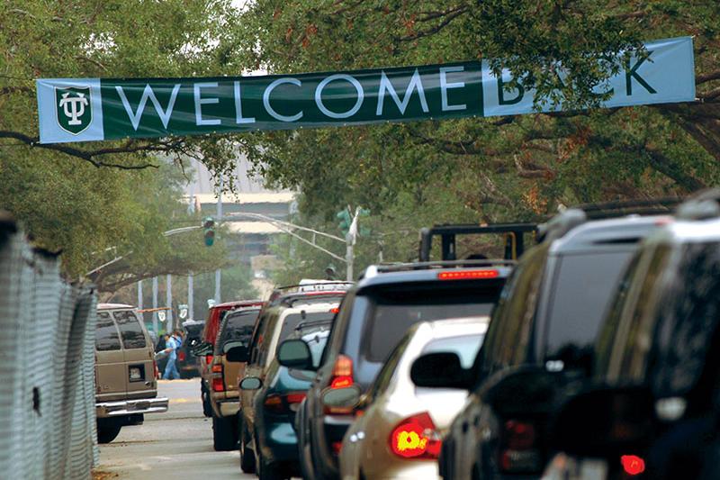 Cars drive on McAlister Drive under Welcome Back banner