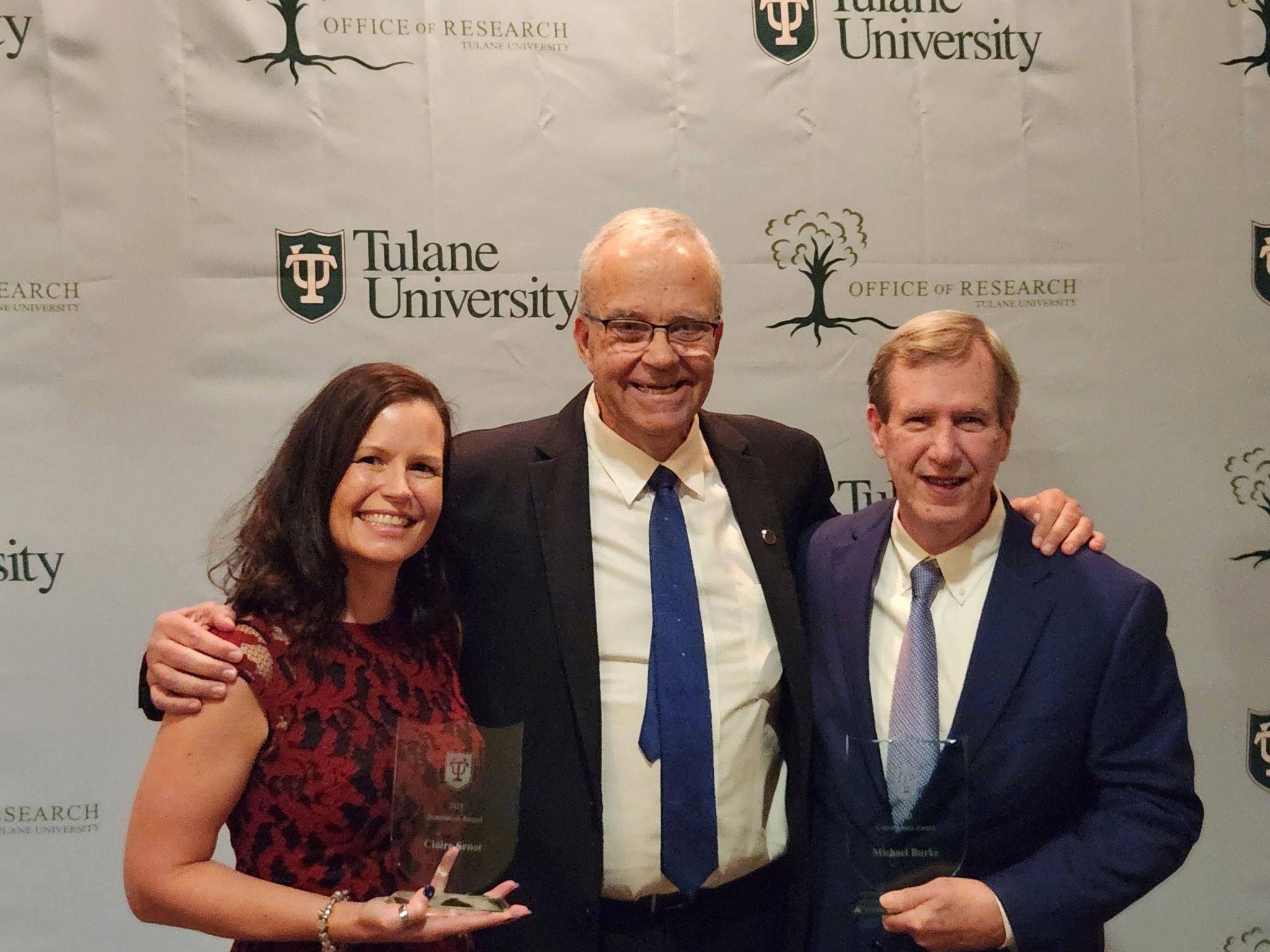 Claire Senot and Mike Burke pose with their awards with Dean Paulo Goes