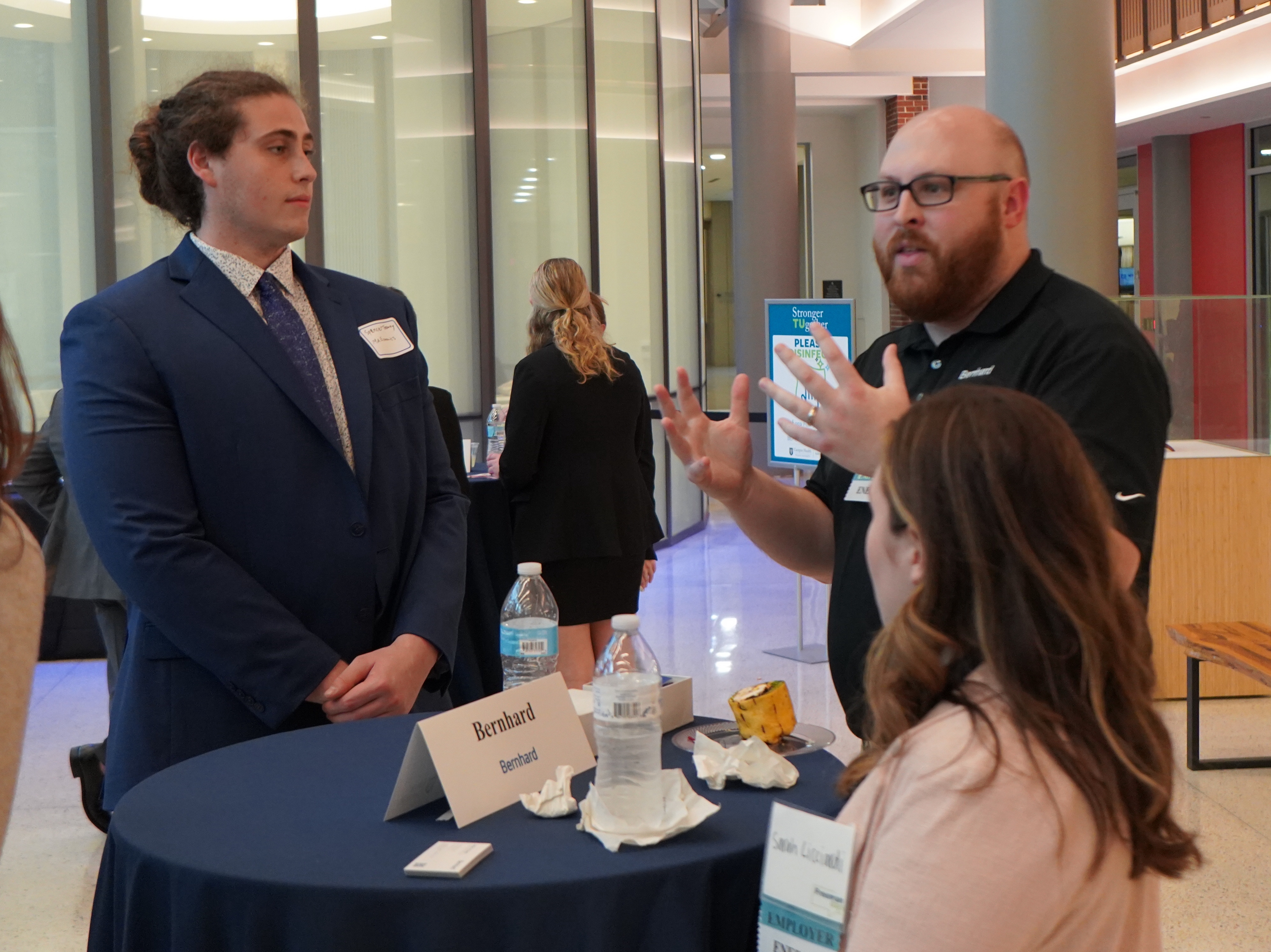 Students networking with representative from Bernhard