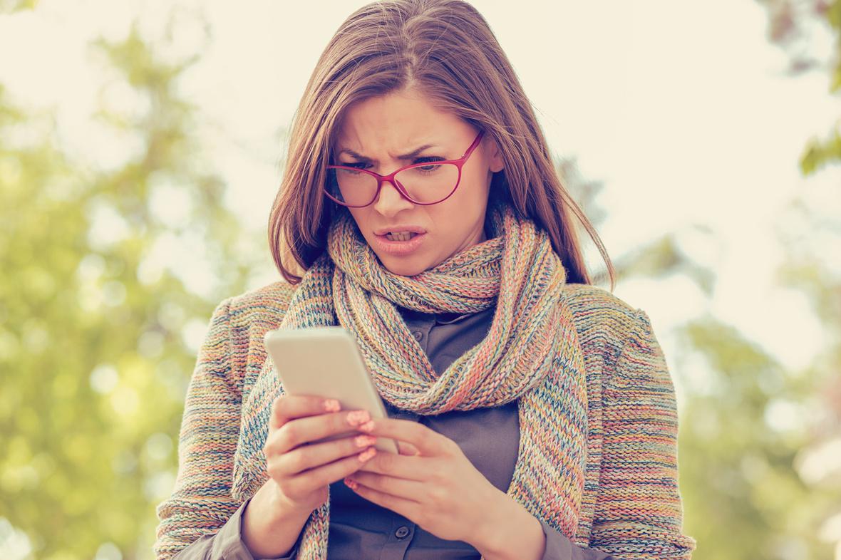 Stock image of woman reacting negatively to social media on phone