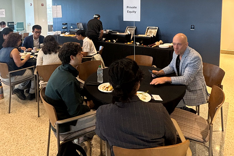 Alternative Investment Conference Presenter and two students talk while sitting at a table in the executive dining room