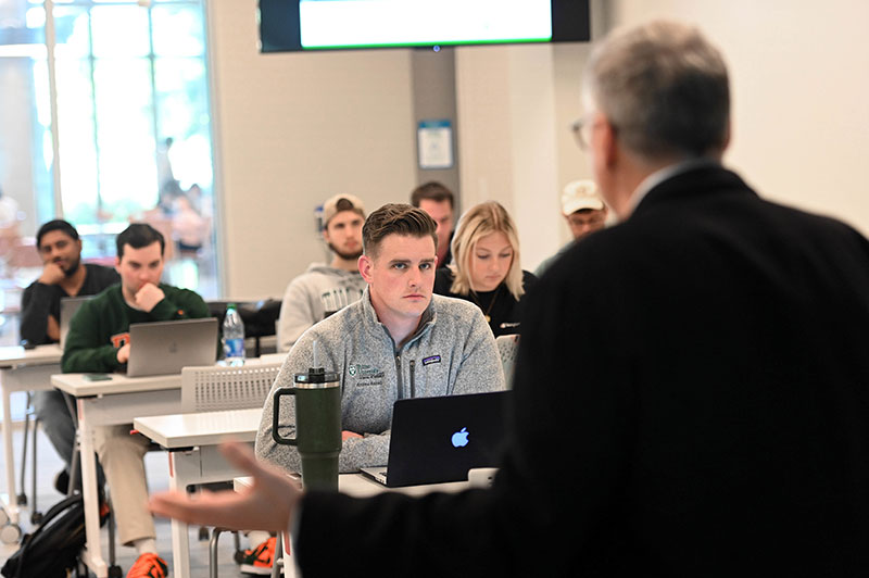 Professor teaches business school class in Goldring/Woldenberg Business Complex