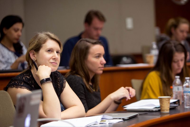 A graduate student listens during a lecture. 