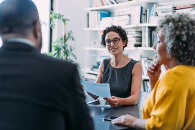 A management consultant meets with clients in an office.  