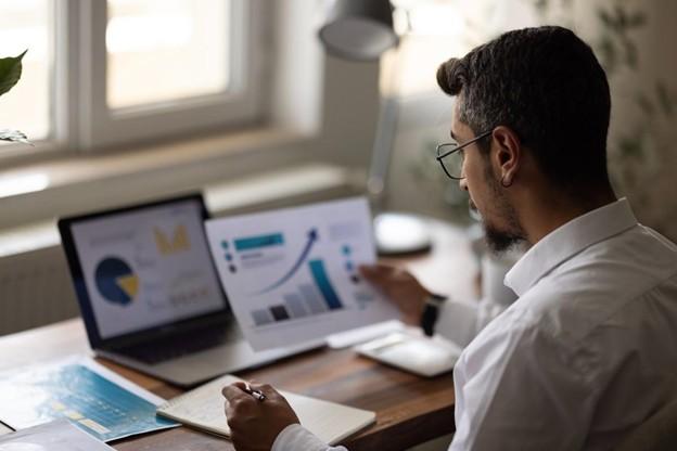An accountant takes notes while reviewing financial data.