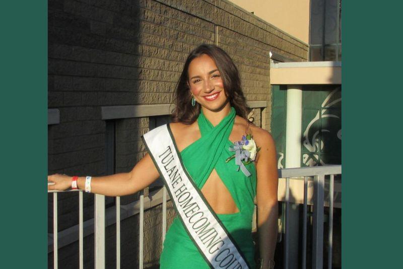 Smiling woman in green dress with "Tulane Homecoming Court" sash and corsage.