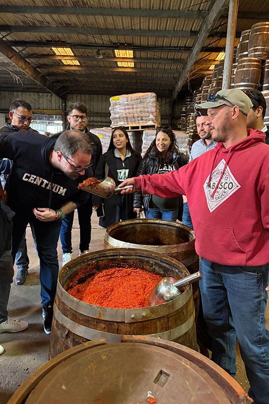 Employee shows Centrum students mash used to make Tabasco pepper sauce