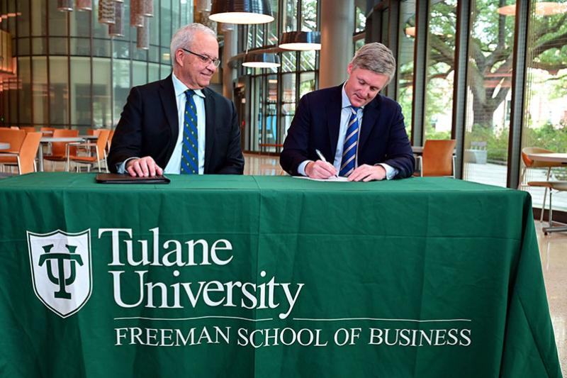 Paulo Goes watches as Rob Guthrie signs Executive Certificate Program agreement