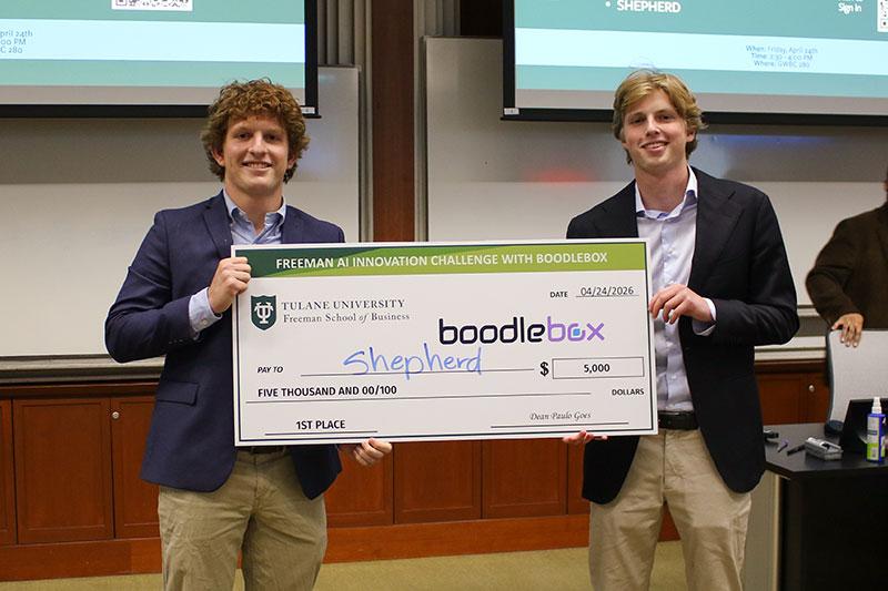 Smiling men hold a "1st Place" $5,000 check from Tulane's AI Innovation Challenge.