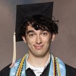 Taylor Friedman smiling graduate in cap, gown, and colorful academic stole