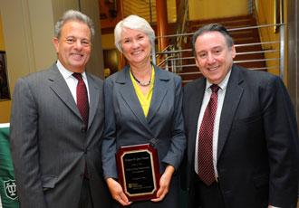 Hannan receives a plague recognizing her investiture from Tulane Provost Michael Bernstein, left, and Freeman School Dean Ira Solomon.