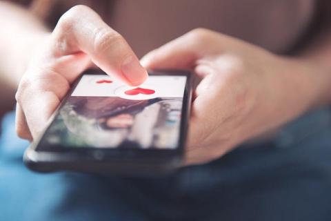 Stock photo of person using dating app on phone