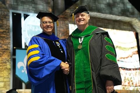 Dr. Peter Kastl is congratulated by Dean Paulo Goes after receiving his diploma.