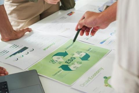 A close-up of finance professionals pointing to documents labeled “ESG.”