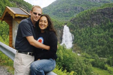 A couple stands in front of a waterfall