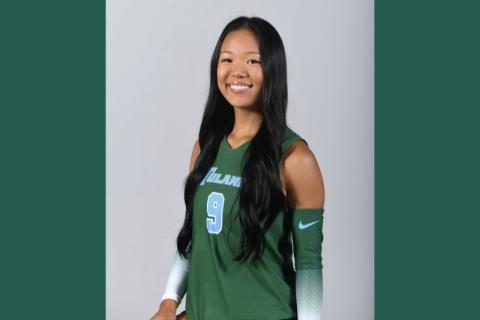 Smiling woman in a green Tulane sports jersey with number 9.