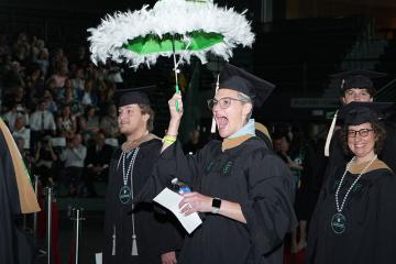 EMBA student JR Comeaux second lines into Fogelman Arena for graduation ceremony.